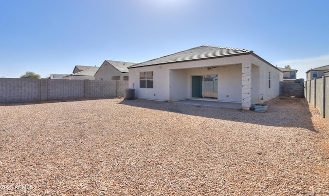 back of house with a tile roof, a patio area, a fenced backyard, and stucco siding