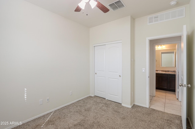 unfurnished bedroom featuring baseboards, visible vents, and light colored carpet