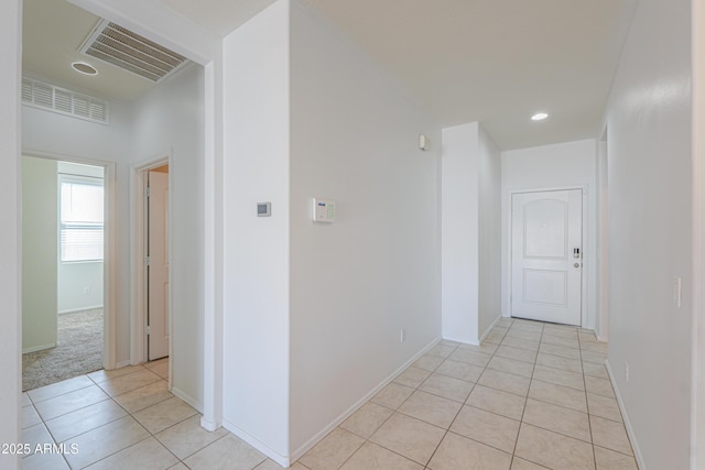 hallway with light tile patterned floors, baseboards, visible vents, and recessed lighting