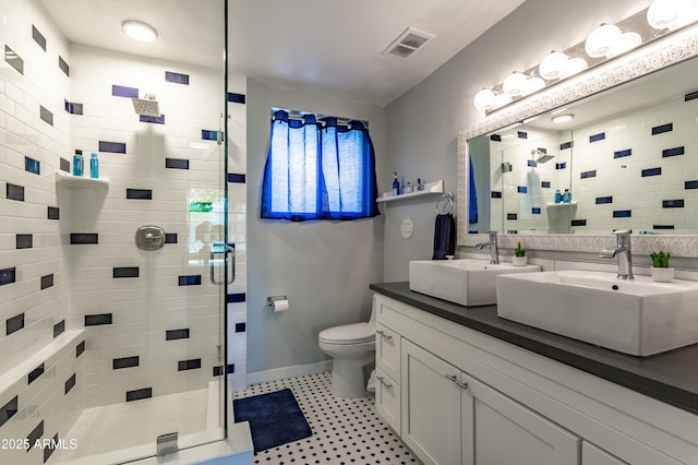 bathroom featuring toilet, vanity, and a shower with door