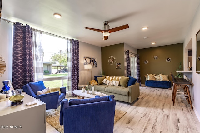 living room featuring light wood-type flooring and ceiling fan