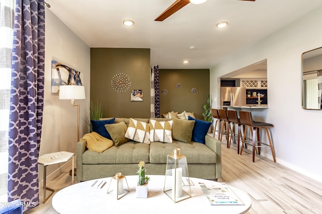 living room featuring ceiling fan and hardwood / wood-style flooring