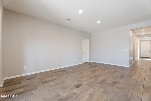 unfurnished room with light wood-style floors, recessed lighting, visible vents, and baseboards