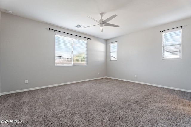 unfurnished room featuring visible vents, carpet, a ceiling fan, and baseboards