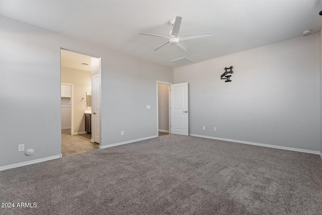 unfurnished bedroom featuring ensuite bathroom, ceiling fan, and light colored carpet