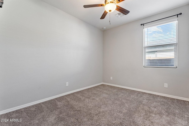 carpeted spare room with a ceiling fan, visible vents, vaulted ceiling, and baseboards