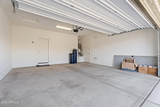 garage with water heater, baseboards, and a garage door opener