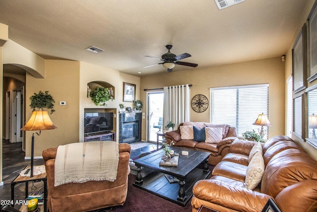 living room featuring ceiling fan, plenty of natural light, and a textured ceiling