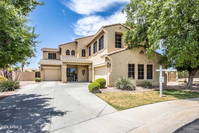 mediterranean / spanish-style home featuring a front yard and a garage