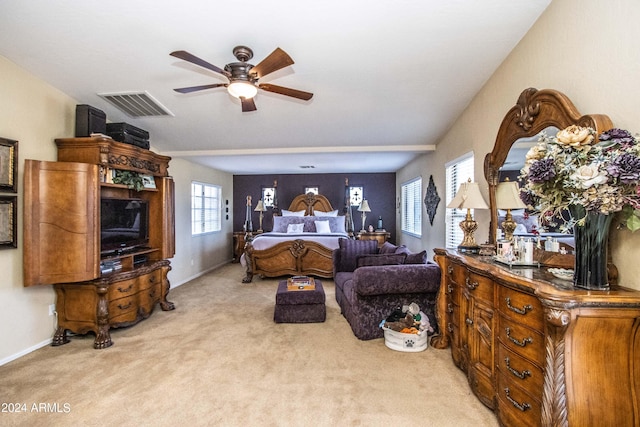 carpeted bedroom with ceiling fan and multiple windows