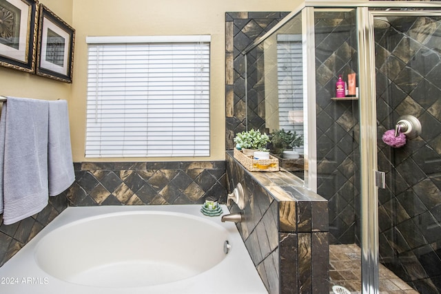 bathroom featuring independent shower and bath