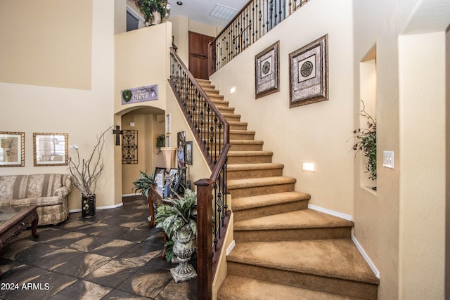 stairs featuring a towering ceiling