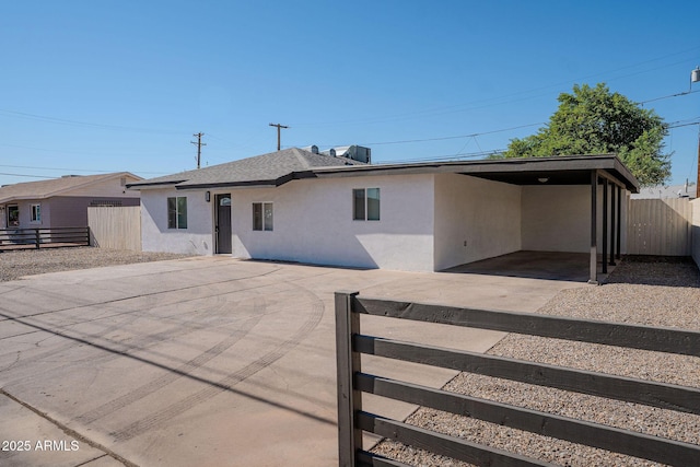 6130 N 27th Ave, Phoenix, AZ 85017 - rear view of house with a carport, fence, stucco siding, and concrete driveway