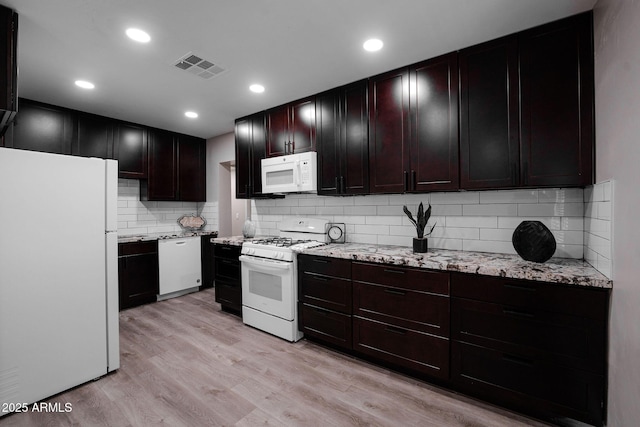 6130 N 27th Ave, Phoenix, AZ 85017 - kitchen with white appliances, light wood-style flooring, visible vents, light stone counters, and backsplash