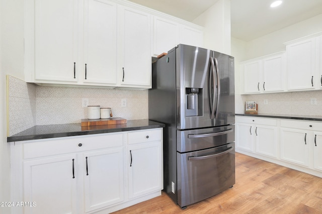 kitchen featuring white cabinets, tasteful backsplash, light wood-type flooring, and stainless steel fridge with ice dispenser