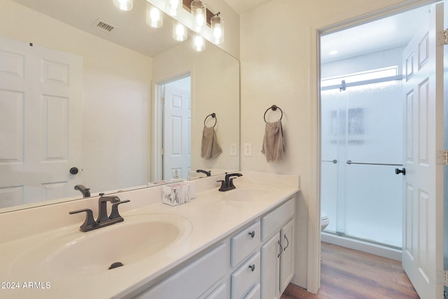 bathroom with vanity, toilet, an enclosed shower, and hardwood / wood-style floors