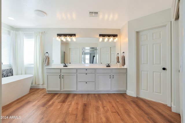 bathroom with vanity, hardwood / wood-style floors, and a bathing tub