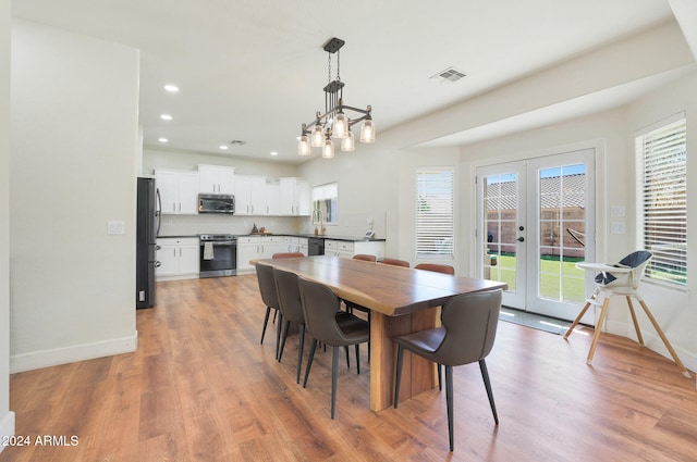 dining room featuring sink, french doors, a notable chandelier, and light hardwood / wood-style floors