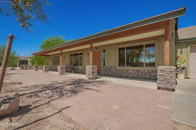 4621 S 179th Dr, Goodyear, AZ 85338 - rear view of house with stone siding, stucco siding, and a porch