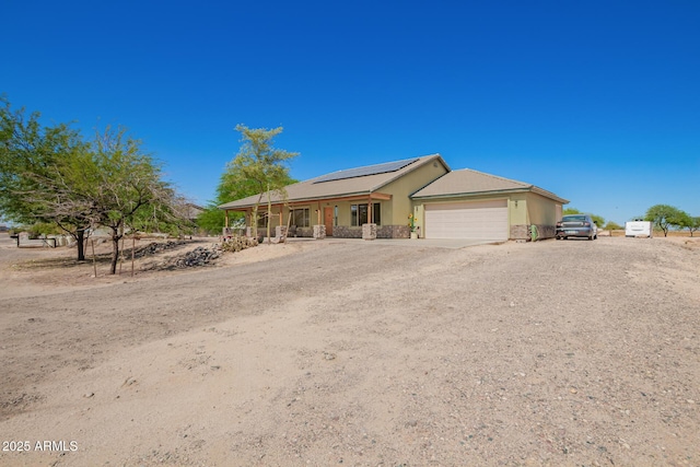 4621 S 179th Dr, Goodyear, AZ 85338 - ranch-style home featuring a garage, solar panels, covered porch, and dirt driveway