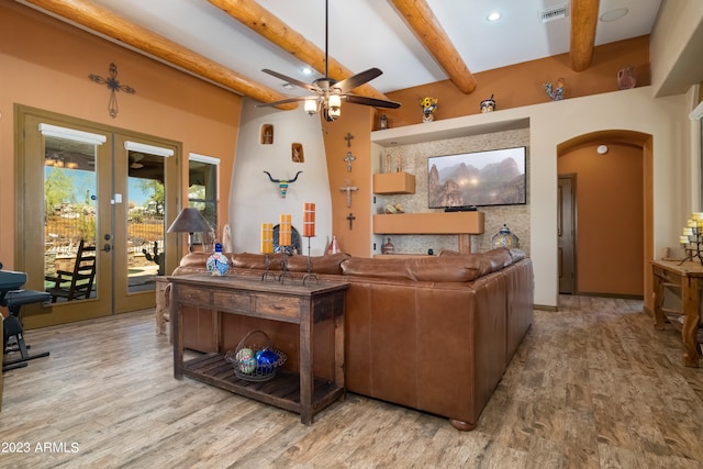 living room with ceiling fan, light hardwood / wood-style floors, french doors, and beamed ceiling