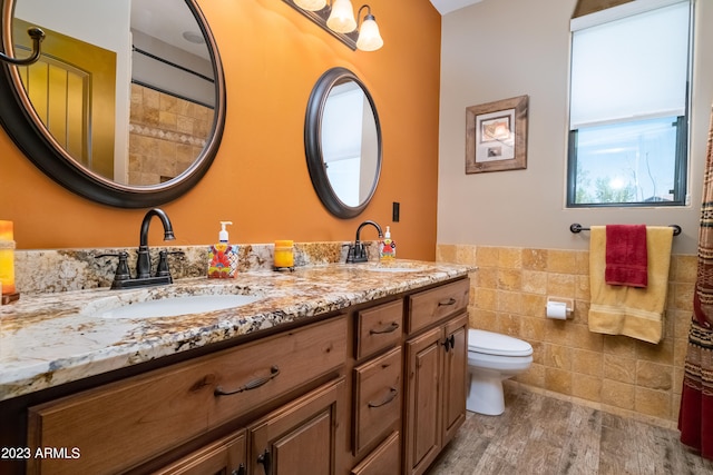 bathroom with vanity, toilet, hardwood / wood-style floors, and tile walls