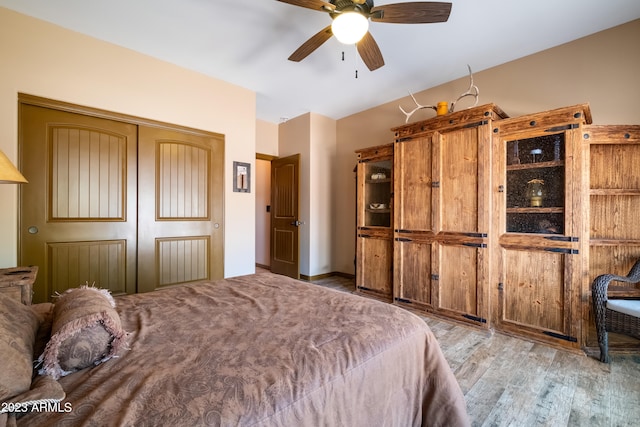 bedroom with hardwood / wood-style flooring, ceiling fan, and a closet