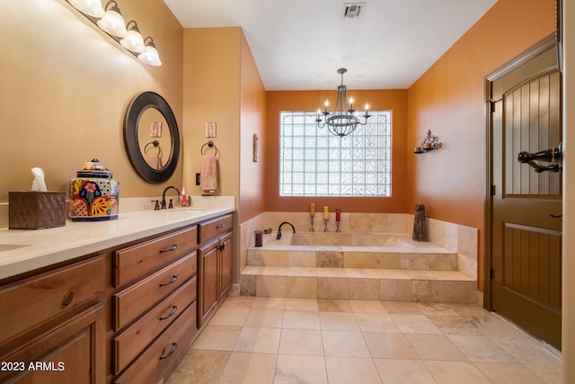 bathroom featuring tiled tub, vanity, tile patterned floors, and a chandelier