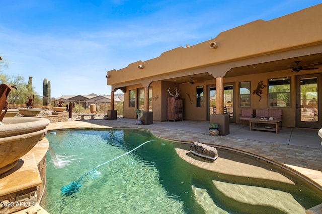 view of swimming pool featuring ceiling fan and a patio area