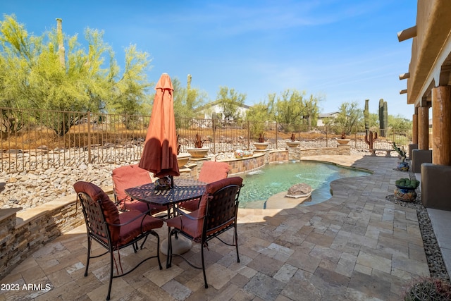 view of swimming pool with pool water feature and a patio