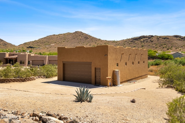 view of front of property with a garage and a mountain view