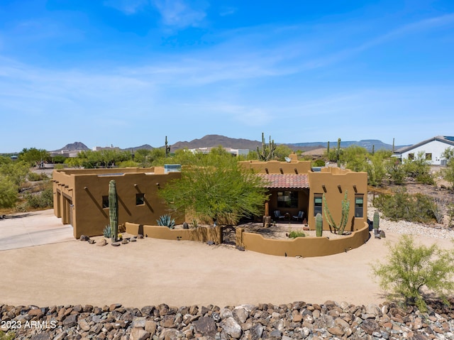 back of house featuring a garage and a mountain view