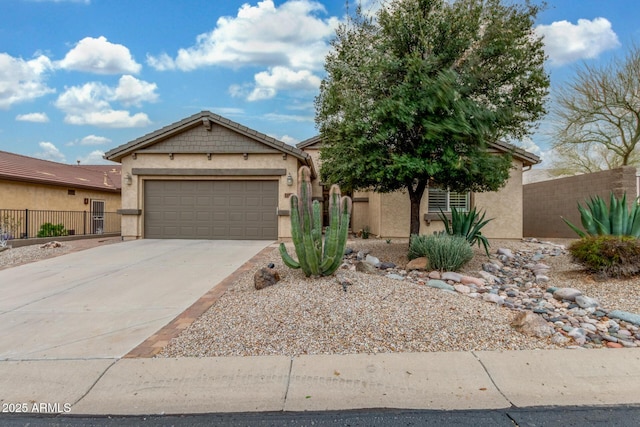 view of front of home featuring an attached garage, fence, driveway, and stucco siding