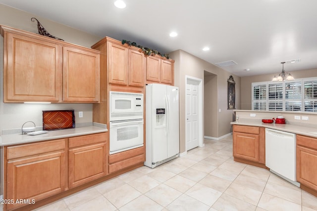 kitchen with a chandelier, recessed lighting, white appliances, and light countertops