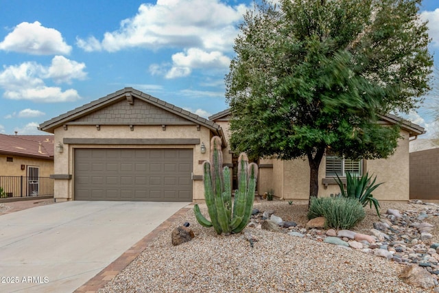 view of front of home with stucco siding, an attached garage, concrete driveway, and fence