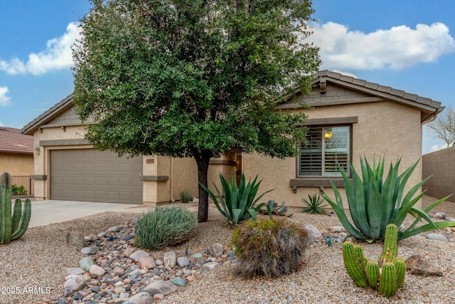 view of front of house with a tile roof, stucco siding, driveway, and an attached garage