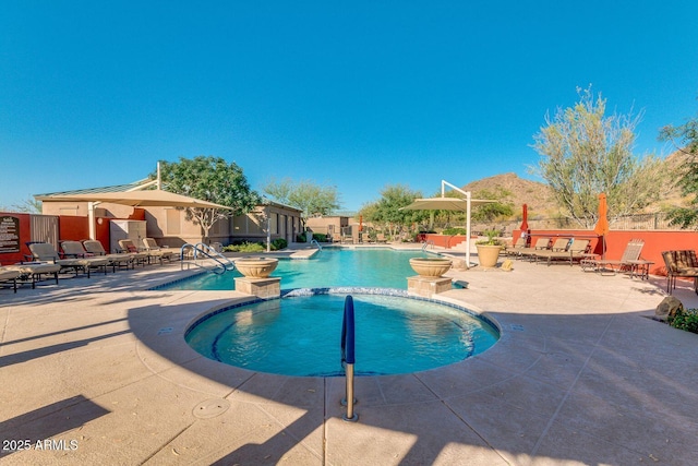 community pool with a patio, a community hot tub, and fence