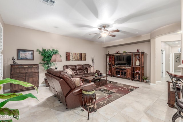 living area with light tile patterned flooring, visible vents, baseboards, and a ceiling fan