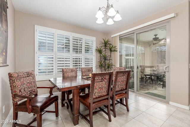 dining area featuring light tile patterned flooring, a notable chandelier, and baseboards