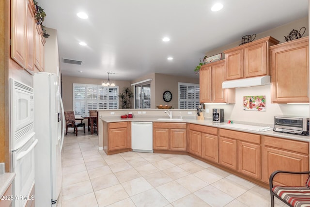 kitchen with visible vents, white appliances, light countertops, and a peninsula