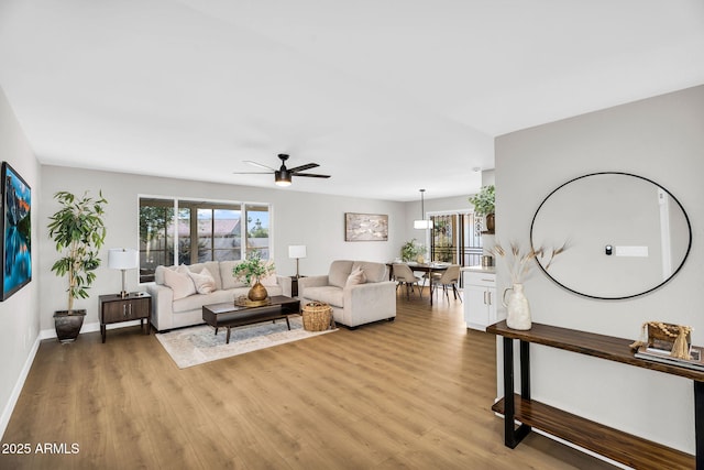 25810 S Boxwood Dr, Sun Lakes, AZ 85248 - living room featuring light wood-style flooring, plenty of natural light, ceiling fan, and baseboards