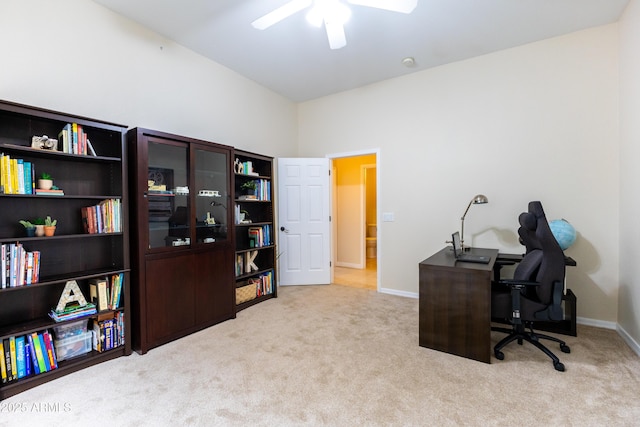 carpeted office featuring baseboards and ceiling fan