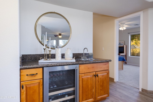 bar featuring wet bar, wine cooler, a sink, and ceiling fan