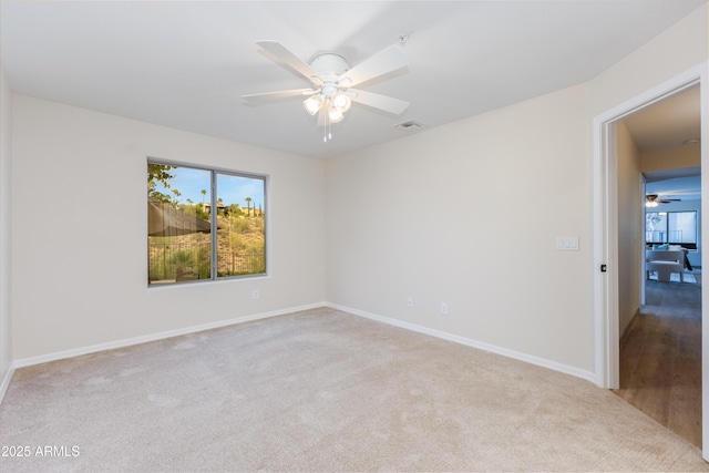 carpeted empty room featuring visible vents, baseboards, and ceiling fan