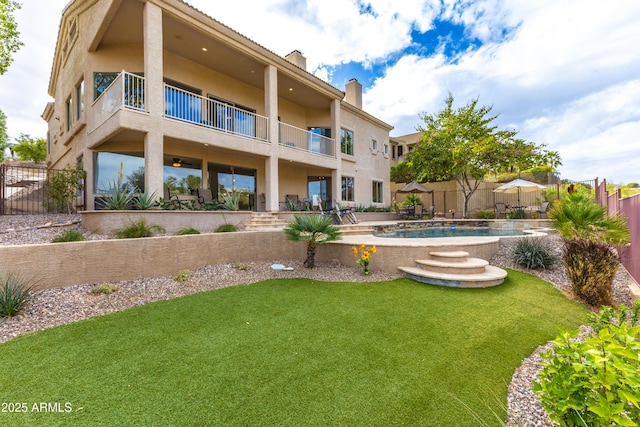 back of house with a patio, a balcony, fence, a yard, and a chimney