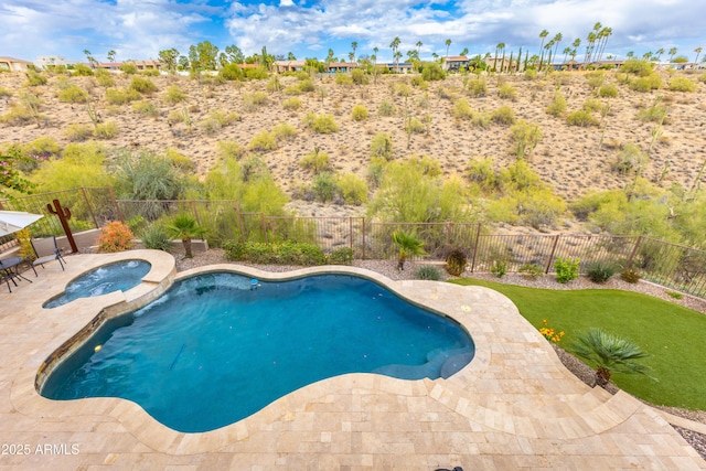 view of swimming pool with a fenced backyard, a pool with connected hot tub, and a patio