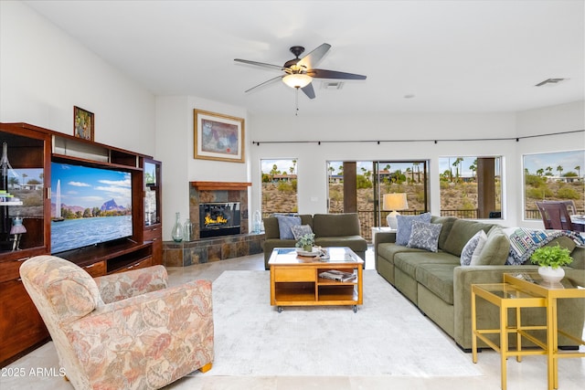 living area with a fireplace, visible vents, and ceiling fan