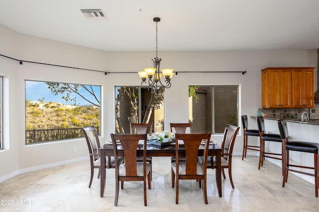 dining area with an inviting chandelier, baseboards, and visible vents