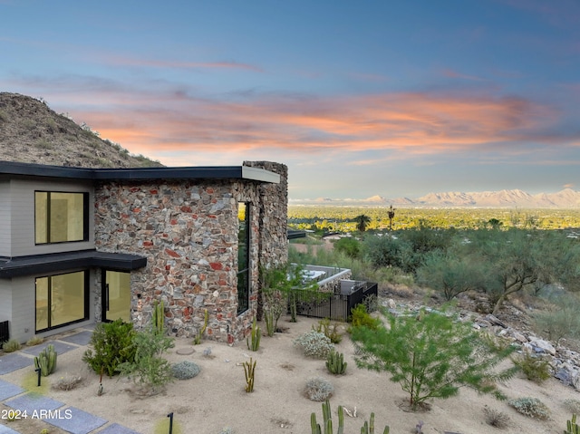 property exterior at dusk with a mountain view