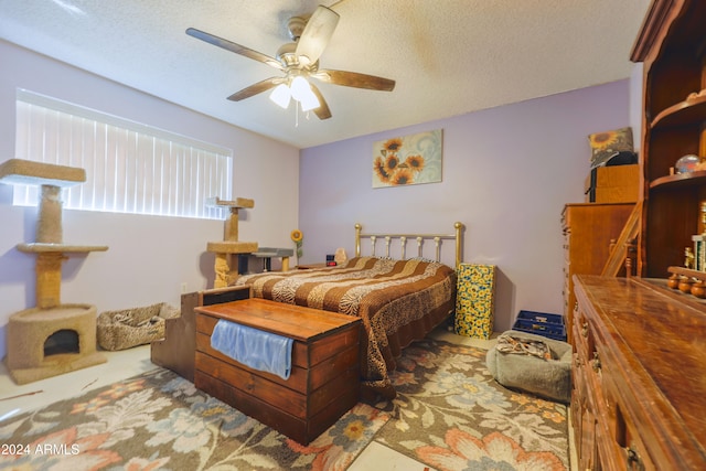 bedroom with ceiling fan and a textured ceiling